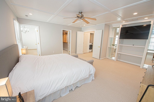 carpeted bedroom with ceiling fan with notable chandelier, washer / dryer, a walk in closet, and a closet