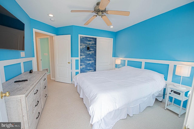 bedroom featuring light carpet, a closet, and ceiling fan