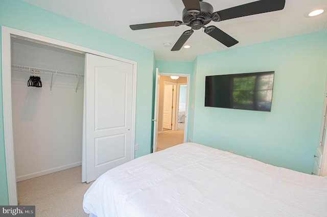 bedroom featuring ceiling fan, light colored carpet, and a closet