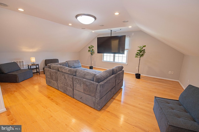 living room with light hardwood / wood-style flooring and vaulted ceiling