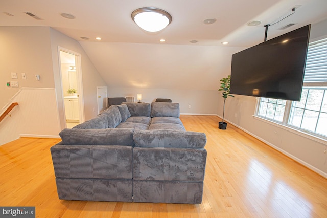 living room featuring lofted ceiling and light wood-type flooring