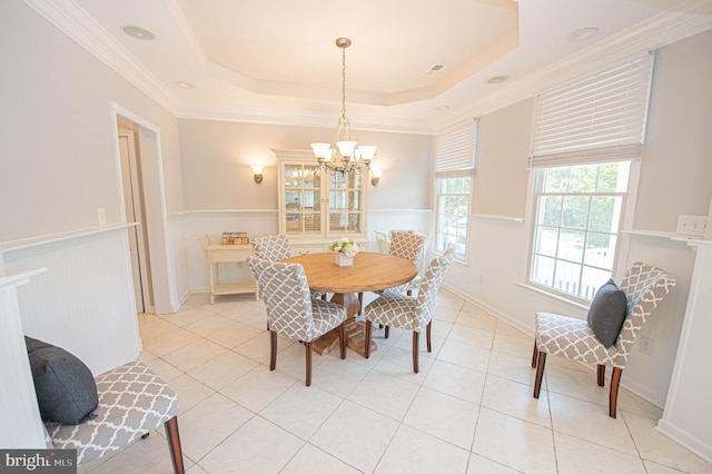 dining space with a notable chandelier, a raised ceiling, ornamental molding, and light tile patterned floors