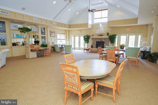 dining space featuring a wealth of natural light, french doors, high vaulted ceiling, and light colored carpet