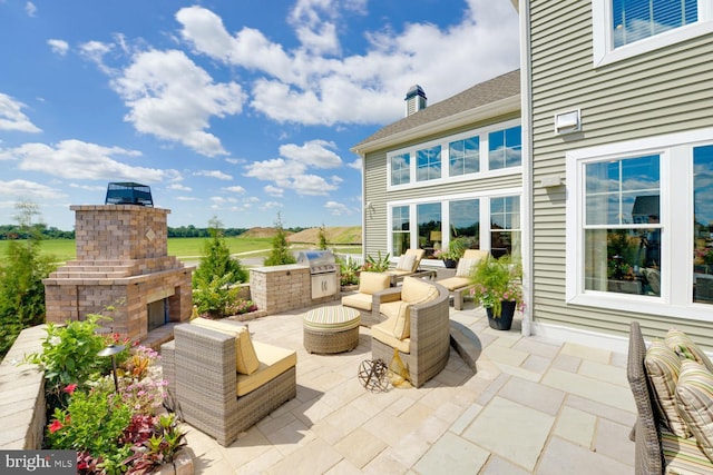 view of terrace featuring area for grilling and an outdoor living space with a fireplace