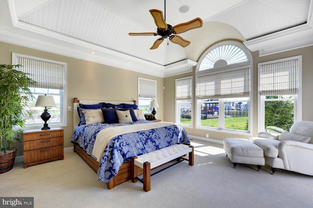 carpeted bedroom featuring a tray ceiling, ornamental molding, and ceiling fan