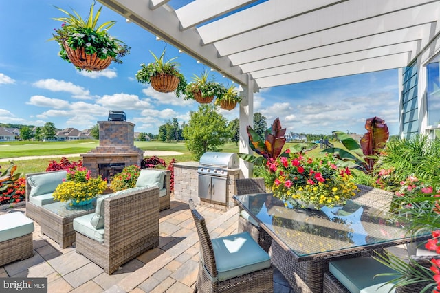 view of patio / terrace with a pergola, an outdoor living space with a fireplace, grilling area, and exterior kitchen