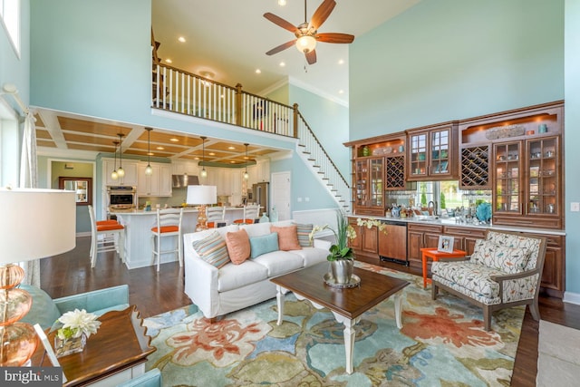 living room featuring a high ceiling, coffered ceiling, dark wood-type flooring, and ceiling fan