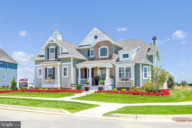 view of front of property featuring covered porch, a front yard, and central AC unit