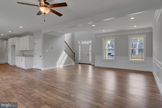 unfurnished living room featuring dark hardwood / wood-style floors, ceiling fan, and ornamental molding