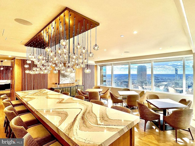 kitchen with light hardwood / wood-style flooring, a kitchen island, a kitchen breakfast bar, and decorative light fixtures