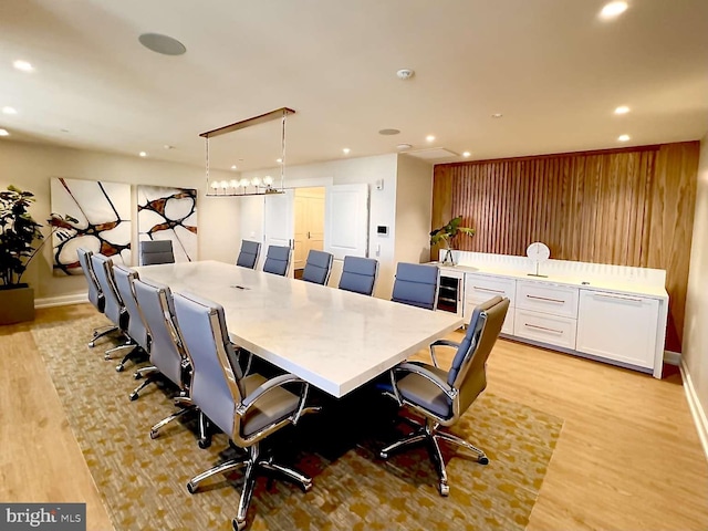 dining area with wood walls and light hardwood / wood-style floors