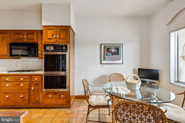 kitchen with black appliances, light tile flooring, and backsplash