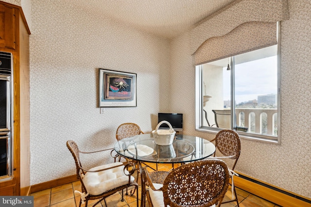 dining room with a baseboard radiator and light tile floors