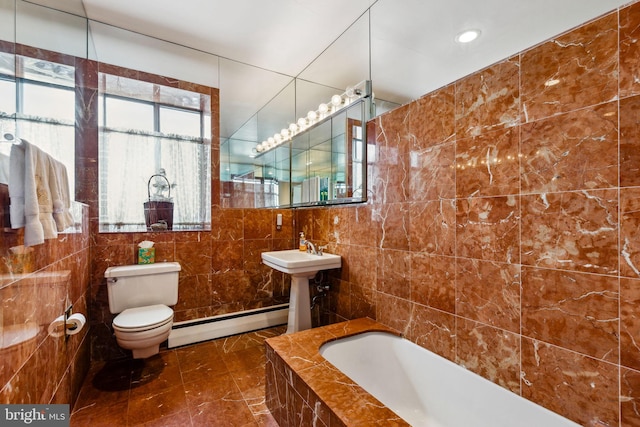 bathroom featuring tile flooring, toilet, baseboard heating, and tile walls