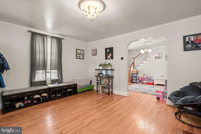 interior space featuring crown molding, light hardwood / wood-style floors, and a notable chandelier