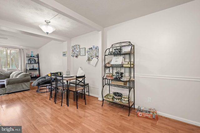 dining area featuring light hardwood / wood-style floors and beam ceiling