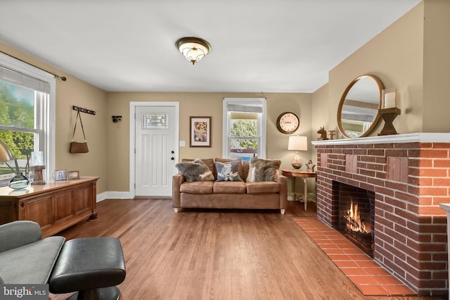 living room with hardwood / wood-style floors, a brick fireplace, and a wealth of natural light