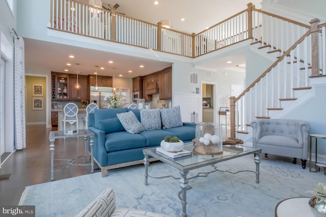 living room featuring a towering ceiling and wood-type flooring