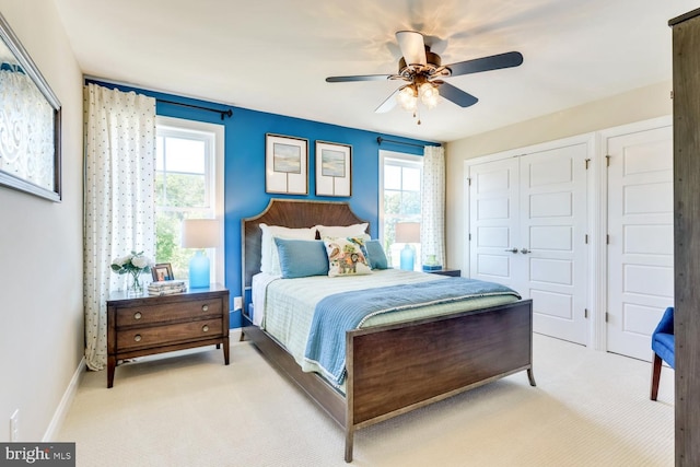 carpeted bedroom with multiple windows and ceiling fan