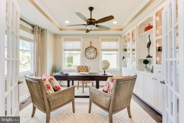 living area featuring light parquet floors, a raised ceiling, ceiling fan, and french doors