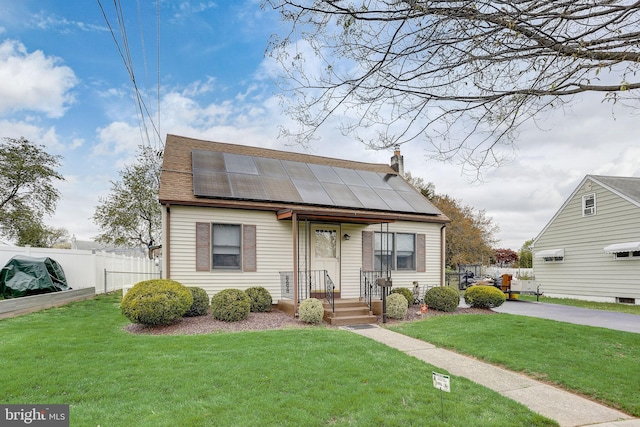 bungalow-style house with solar panels and a front yard