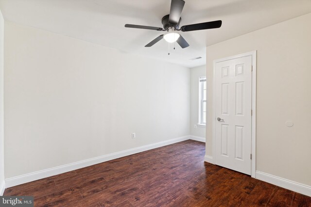 empty room with ceiling fan and dark hardwood / wood-style flooring