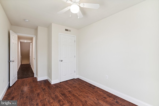 unfurnished bedroom featuring dark hardwood / wood-style floors and ceiling fan