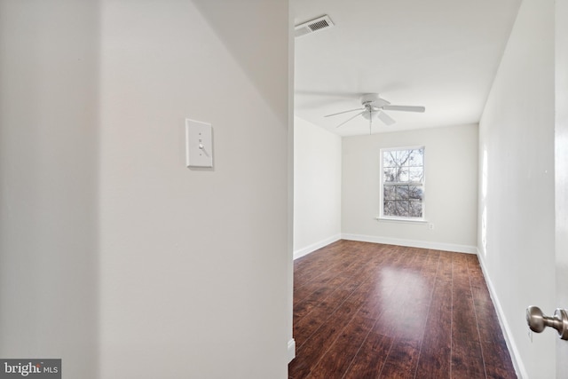 empty room featuring ceiling fan and dark wood-type flooring