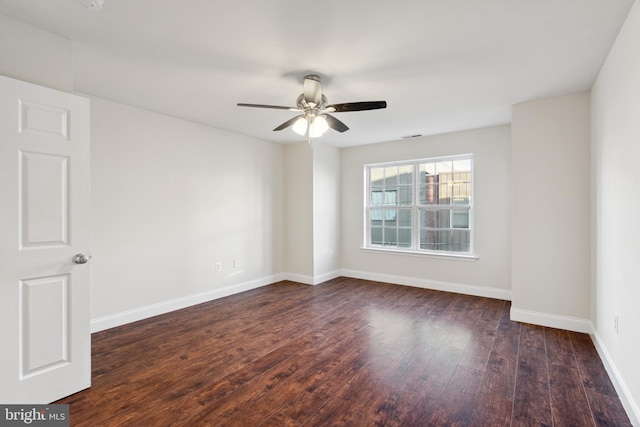 empty room with dark hardwood / wood-style flooring and ceiling fan