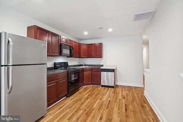 kitchen with sink, light wood-type flooring, and black appliances