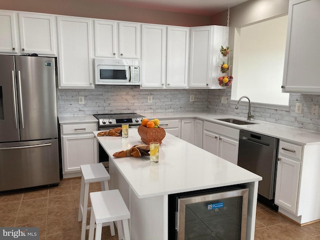 kitchen featuring sink, backsplash, wine cooler, and stainless steel appliances