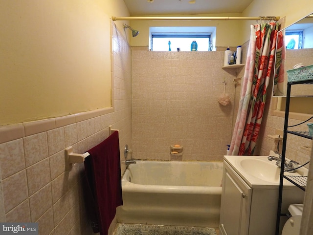 full bathroom with tile walls, shower / bath combination with curtain, toilet, and oversized vanity