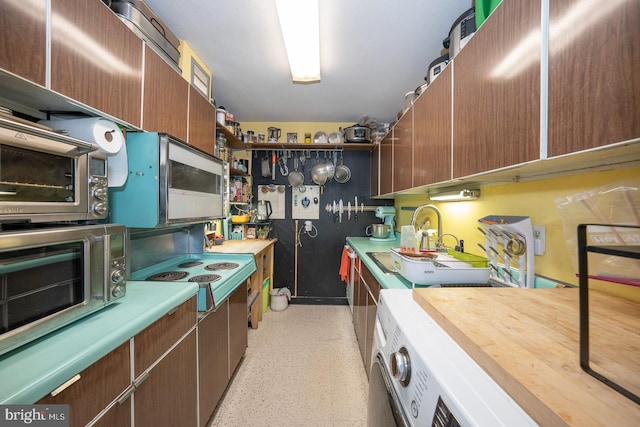 kitchen with stovetop, sink, and washer / dryer