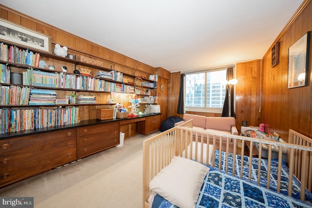 bedroom featuring wooden walls and light colored carpet