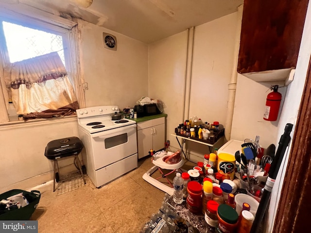 kitchen featuring electric range and light tile floors