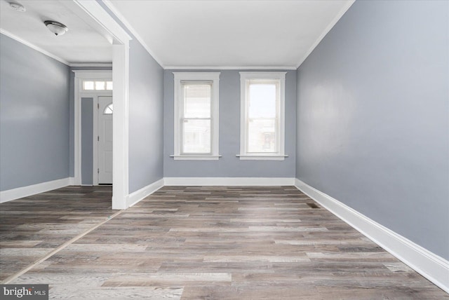 unfurnished room with a healthy amount of sunlight, hardwood / wood-style flooring, and crown molding