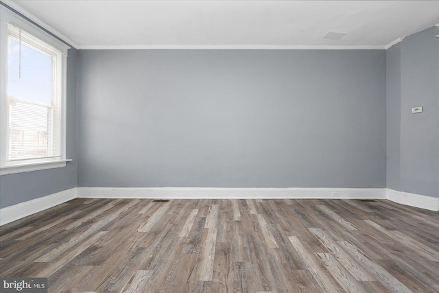 spare room with dark hardwood / wood-style flooring, a healthy amount of sunlight, and ornamental molding