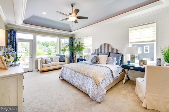 carpeted bedroom with a raised ceiling, ornamental molding, ceiling fan, and access to outside