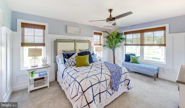 bedroom with light carpet, ceiling fan, and multiple windows