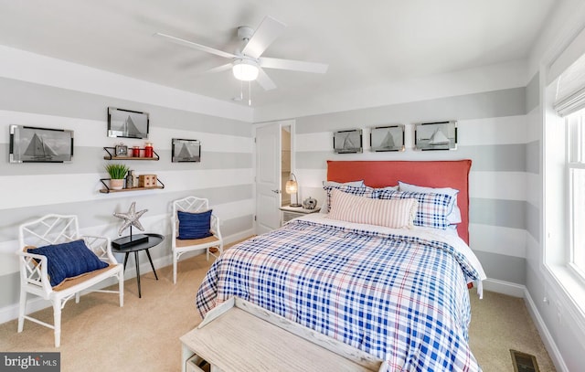 bedroom with light carpet, ceiling fan, and multiple windows