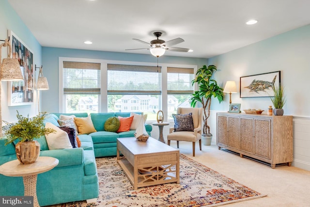 carpeted living room with ceiling fan