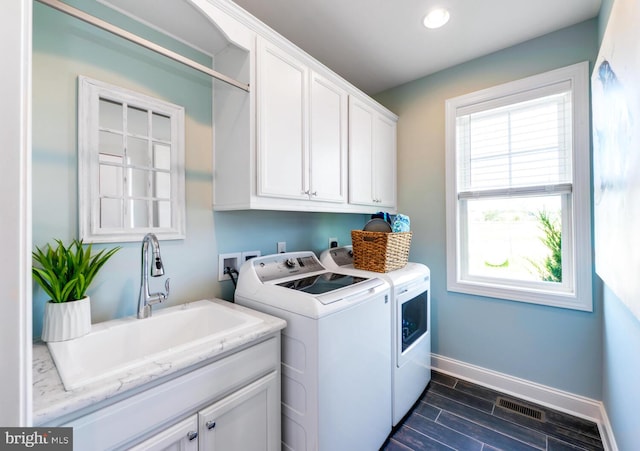 clothes washing area with cabinets, hookup for an electric dryer, sink, hookup for a washing machine, and washing machine and clothes dryer