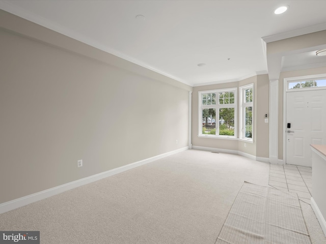 carpeted foyer entrance with ornamental molding