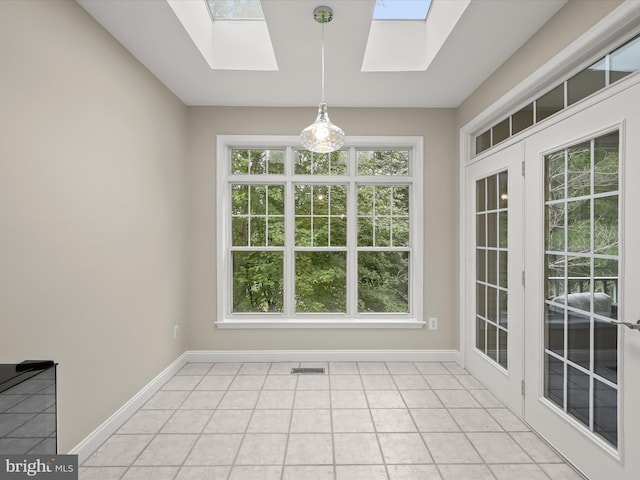 unfurnished dining area with light tile patterned floors and a skylight