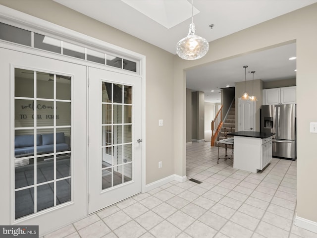 kitchen with pendant lighting, white cabinetry, a kitchen breakfast bar, light tile patterned floors, and stainless steel fridge with ice dispenser