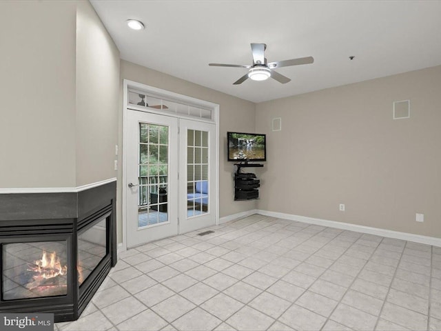 unfurnished living room with a multi sided fireplace and ceiling fan