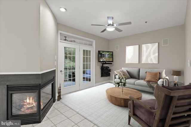 tiled living room featuring ceiling fan and a multi sided fireplace