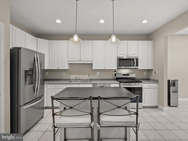 kitchen with sink, decorative light fixtures, light tile patterned floors, stainless steel appliances, and white cabinets