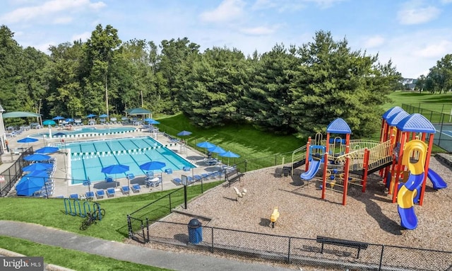 view of playground featuring a community pool and a lawn