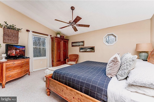 bedroom with ceiling fan, light carpet, vaulted ceiling, and a textured ceiling